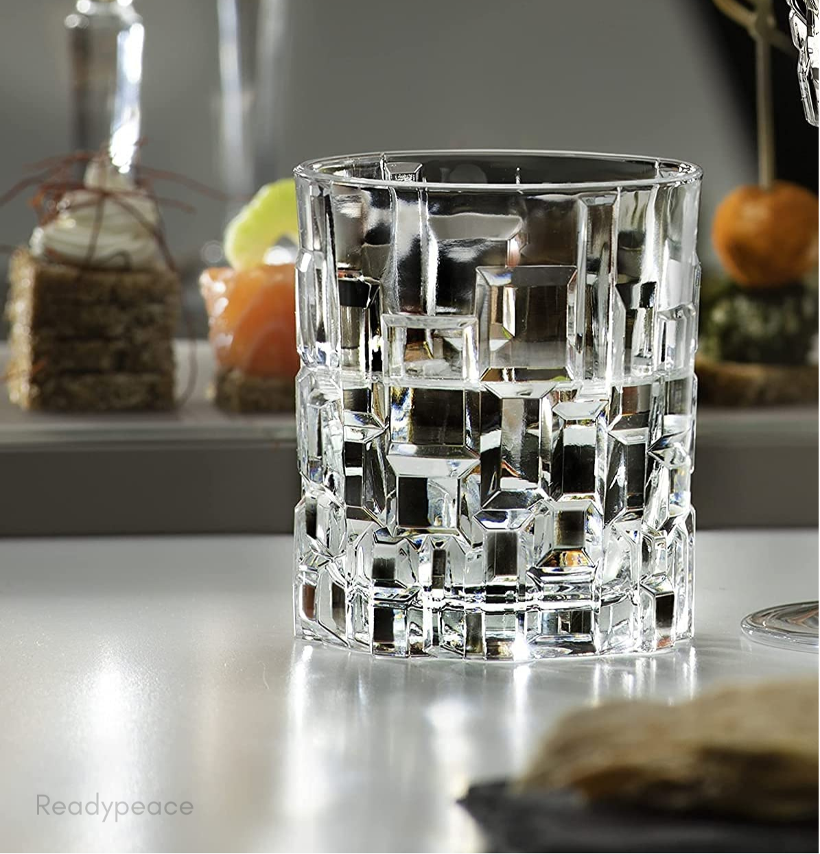 A clear crystal whiskey glass with a geometric engraved pattern.
